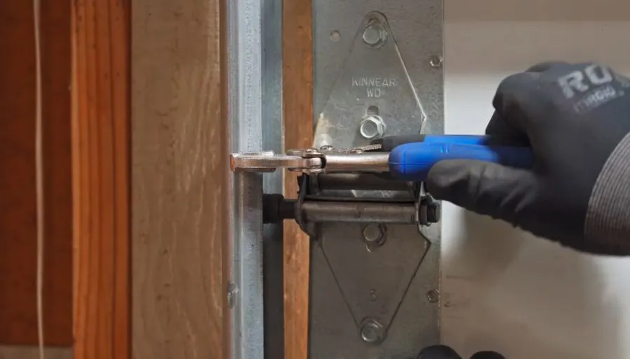 Technician testing garage door spring tension after a repair in Irving, TX