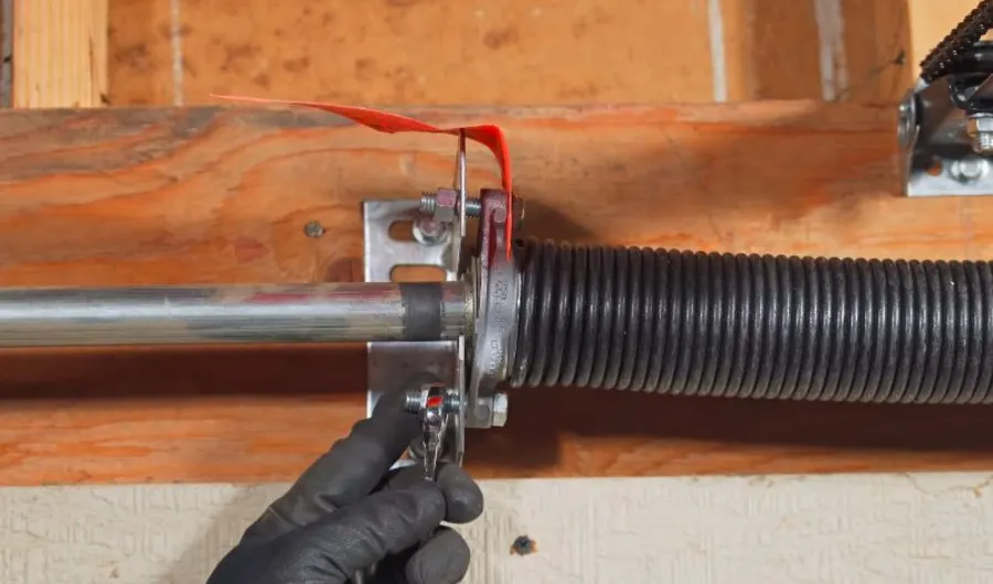 Technician installing a new garage door torsion spring in Irving, TX